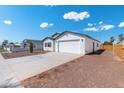 A single-story home with a two-car garage and a lengthy concrete driveway at 410 S 98Th Pl, Mesa, AZ 85208