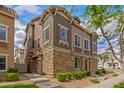 Inviting townhome featuring stacked stone accents, muted green siding, and professional landscaping at 453 N Alder Ct, Gilbert, AZ 85233