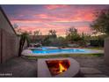 Backyard with a desert landscape featuring a fire pit and a pool with stone accents at 4958 E Desert Vista Trl, Cave Creek, AZ 85331