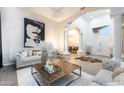 Spacious living room with hardwood floors, modern art, white pillars, and open archway to dining room at 6132 E Yucca St, Scottsdale, AZ 85254