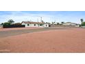 Expansive lot with desert landscaping and a single-story home featuring a light-colored exterior and green door at 8220 N 35Th Ave, Phoenix, AZ 85051