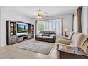 Inviting living room with a modern TV stand, plush seating, and natural light at 10 N Agua Fria Ln, Casa Grande, AZ 85194