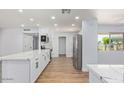 Modern kitchen with white cabinets, stainless steel appliances, quartz countertops, and a breakfast bar at 10839 W Peoria Ave, Sun City, AZ 85351