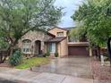 Charming two-story home with a stone facade, well-manicured lawn, mature trees and a spacious two car garage at 1131 W Sierra Madre Ave, Gilbert, AZ 85233