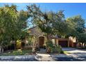 Charming two-story home with a stone facade, well-manicured lawn, mature trees and a spacious two car garage at 1131 W Sierra Madre Ave, Gilbert, AZ 85233