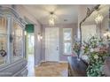 Welcoming foyer with decorative mirror, elegant chandelier, and neutral tile flooring at 1157 W Desert Lily Dr, San Tan Valley, AZ 85143