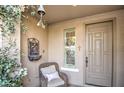 Inviting front entrance with a wicker chair, decorative window, and a charming fountain at 1157 W Desert Lily Dr, San Tan Valley, AZ 85143