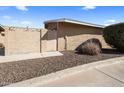 Exterior view of the home with a wooden gate and a gravel area at 1310 S Pima -- # 35, Mesa, AZ 85210