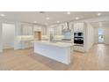 Bright, white kitchen featuring an island and modern appliances at 14770 W Tether Trl, Surprise, AZ 85387