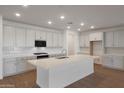 Modern kitchen featuring white cabinets, quartz countertops, stainless steel appliances, and a large center island at 14790 W Tether Trl, Surprise, AZ 85387