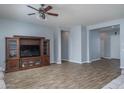 Spacious living room featuring wood-look tile flooring and a large entertainment center at 16492 N 181St Dr, Surprise, AZ 85388