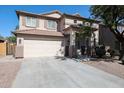 Lovely home showcasing a spacious driveway, neat landscaping, and a welcoming covered porch at 17474 W Acapulco Ln, Surprise, AZ 85388