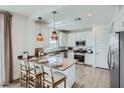 Bright, modern kitchen featuring white cabinets, stainless steel appliances, and a stylish breakfast bar at 3315 S Lotus St, Mesa, AZ 85212