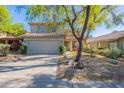 Inviting two-story home with a two-car garage, desert landscaping, and a mature shade tree in the front yard at 4033 E Wildcat Dr, Cave Creek, AZ 85331