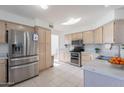 Well-lit kitchen featuring stainless steel appliances, light wood cabinets, tile flooring, and plentiful counter space at 4033 E Wildcat Dr, Cave Creek, AZ 85331