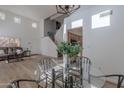 Bright living room with soaring ceilings, wood-look floors, a dining table, and open access to the home's entry and staircase at 4033 E Wildcat Dr, Cave Creek, AZ 85331
