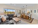 Open-concept living room with dining area featuring large windows and desert views at 41802 N Bridlewood Way, Anthem, AZ 85086