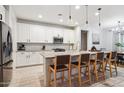 Stylish kitchen with white cabinets, a center island with bar seating, and modern stainless steel appliances at 5428 N 188Th Ln, Litchfield Park, AZ 85340