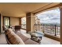 Relaxing outdoor balcony with comfortable seating, a glass table, and views of the cityscape at 7175 E Camelback Rd # 1106, Scottsdale, AZ 85251