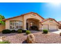 Inviting single-story home with a desert rock front yard, mature landscaping, and arched front porch at 7810 W Wescott Dr, Glendale, AZ 85308