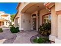 Welcoming front entrance featuring decorative shrubs and a patterned security door with a stone pathway at 7810 W Wescott Dr, Glendale, AZ 85308