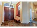 Grand foyer with decorative niche, tiled floor, bench, and elegant lighting at 9126 E Topeka Dr, Scottsdale, AZ 85255