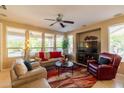 Bright living room with large windows, ceiling fan, and comfortable seating arrangement at 13070 W Eagle Talon Trl, Peoria, AZ 85383