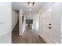 Spacious entryway with sleek gray floors flows into a modern kitchen and staircase, with a front door to the right at 1327 W Glendale Ave, Phoenix, AZ 85021