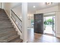 Inviting foyer featuring sleek gray flooring, a staircase with iron railings and a view to the living room at 1327 W Glendale Ave, Phoenix, AZ 85021