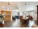 Inviting living and dining area with wood floors, a vaulted ceiling, a large window, and a cozy seating area at 14458 W Powderhorn Dr, Surprise, AZ 85374