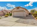 Single-story home with a two-car garage, gravel landscaping, and a tile roof on a sunny day at 17125 W Saguaro Ln, Surprise, AZ 85388