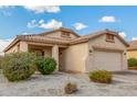 Single-story home featuring desert landscaping, a tile roof, covered porch, and attached two car garage at 17125 W Saguaro Ln, Surprise, AZ 85388