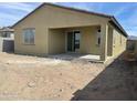 The exterior of a home showcases a covered patio area, and a large dirt backyard offering a blank canvas at 17296 W Desert Sage Dr, Goodyear, AZ 85338