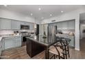 Charming kitchen showcases light blue cabinets, stainless steel appliances, a center island, and hardwood floors at 18776 N 90Th Pl, Scottsdale, AZ 85255