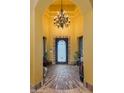 Welcoming entryway with brick floor, decorative front door and chandelier at 2005 N Pomelo --, Mesa, AZ 85215