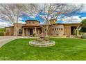 Beautiful home with stone accents, fountain, lush green lawn and a circular driveway at 2005 N Pomelo --, Mesa, AZ 85215