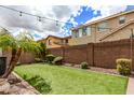 Private backyard oasis featuring artificial turf, mature landscaping, and a secure brick fence at 2116 S Moccasin Trl, Gilbert, AZ 85295