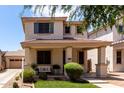 Inviting two-story home featuring a cozy front porch and manicured front lawn at 2116 S Moccasin Trl, Gilbert, AZ 85295
