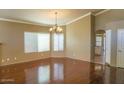 Spacious living room featuring hardwood floors, neutral paint, and a traditional chandelier at 221 E Vaughn Ave, Gilbert, AZ 85234