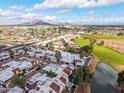 Community aerial view featuring white tile roofs, a golf course, a pond, and mountains in the distance at 2537 N Miller Rd, Scottsdale, AZ 85257