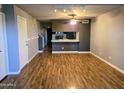 Bright living room with wood floors, ceiling fan, and track lighting leading to open concept kitchen at 30 E Brown Rd # 2052, Mesa, AZ 85201