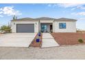 Charming single-story house with an attached garage and meticulously maintained front yard landscaping, providing a welcoming curb appeal at 33608 W Campbell Ave, Tonopah, AZ 85354