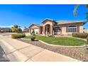 Inviting single-Gathering home featuring lush landscaping, a manicured lawn, and a welcoming entrance at 3542 E Pala Ct, Gilbert, AZ 85297