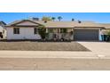 Charming single-story home with a two-car garage and xeriscaped front yard at 3619 E Friess Dr, Phoenix, AZ 85032