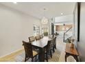 Open-concept dining room with modern light fixture, laminate floors, and ample natural light at 493 E Baylor Ln, Gilbert, AZ 85296
