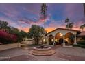 Elegant home featuring a circular driveway, a fountain, a tiled roof, and beautiful arched architecture at 5254 E Arroyo Rd, Paradise Valley, AZ 85253