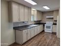 Bright kitchen showcasing light cabinets, dark countertops, tile backsplash and modern appliances on newer floors at 549 E Mckellips Rd # 55, Mesa, AZ 85203