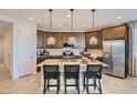 Contemporary kitchen with large island, pendant lighting, stainless appliances, and dark wood cabinets at 8108 E Paloma Ave, Mesa, AZ 85212