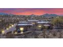 Desert home at dusk with mountain views, lit landscape, and circular driveway at 8154 E Tecolote Cir, Scottsdale, AZ 85266