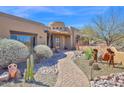 Front Entrance with desert landscaping, pottery, a brick walkway, and wooden door at 8154 E Tecolote Cir, Scottsdale, AZ 85266